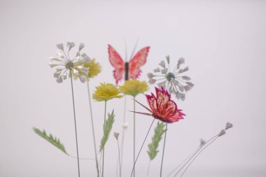 Spring composition with paper flowers and butterfly on white background