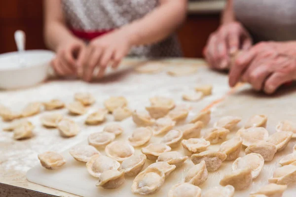 Menina com avó na cozinha esculpe bolinhos — Fotografia de Stock