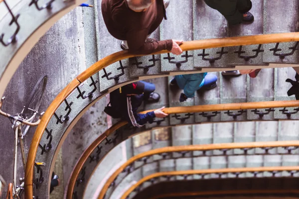 As pessoas descem e sobem as escadas velhas escadas em espiral, escadas em espiral dentro de uma antiga casa em Budapeste, Hungria — Fotografia de Stock