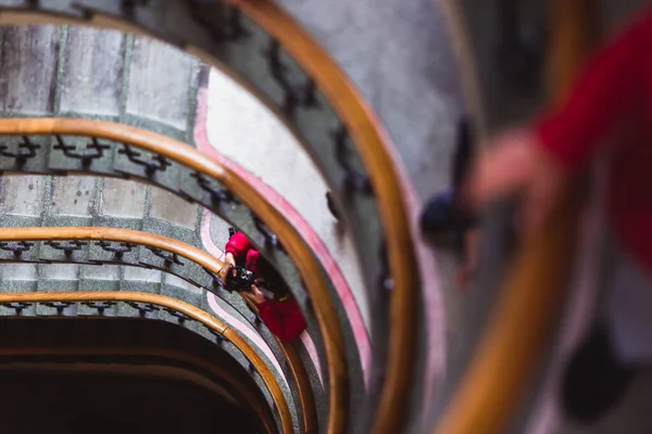 As pessoas descem e sobem as escadas velhas escadas em espiral, escadas em espiral dentro de uma antiga casa em Budapeste, Hungria — Fotografia de Stock