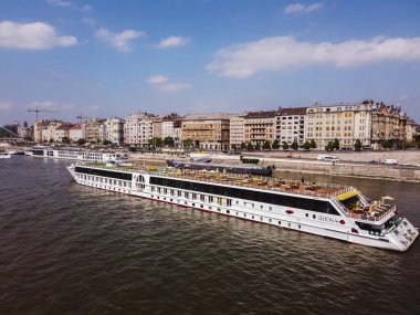 Budapeşte 'de Tuna Nehri' ndeki River Cruise tekneleri - Nisan 2019 Kıyıda ve nehirde seyahat gemileri. Liberty Köprüsü 'nden nehir kıyısının panoramik görüntüsü