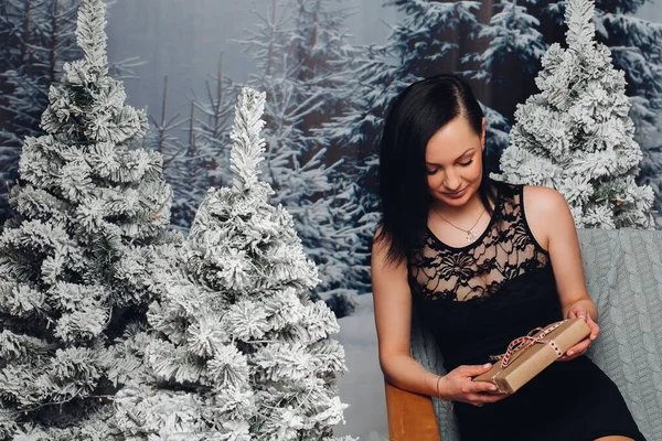 크리스마스가 되어 전나무에 앉아 있는 아름다운 여인. — 스톡 사진