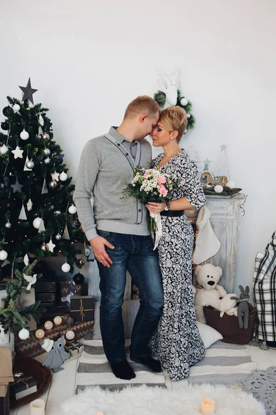 Hermosa pareja con ramo en el árbol de Navidad . — Foto de Stock