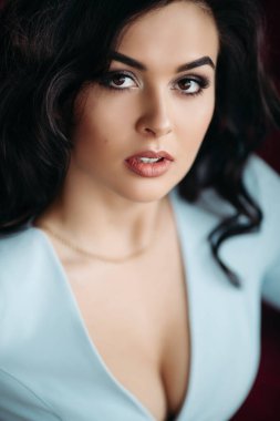 Baştan çıkarıcı, mavi elbiseli, baştan çıkarıcı bir esmer, kameraya bakıyor..