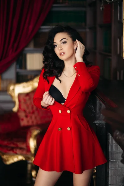 Σέξι κορίτσι με κόκκινο φόρεμα undresiing αγγίζοντας το στήθος της και γδύσιμο. — Φωτογραφία Αρχείου