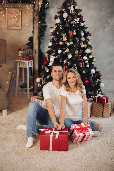 Liebespaar mit Geschenken gegen den Weihnachtsbaum. — Stockfoto