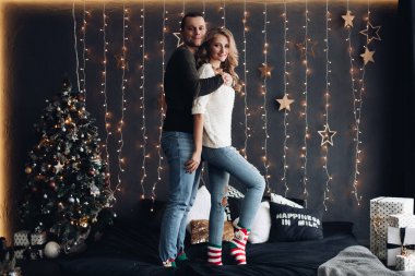 Noel için süslü odada gülümseyen bir çift..