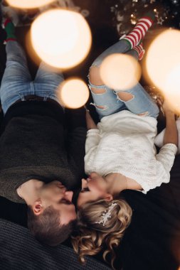 Yatakta romantik bir çift. Işıkların altında yüz yüze yatıyorlar..