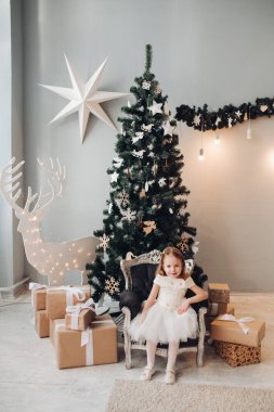 Noel ağacının yanında güzel küçük bir kız. Tam boy stok fotoğrafı