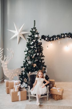 Noel ağacının yanında güzel küçük bir kız. Tam boy stok fotoğrafı
