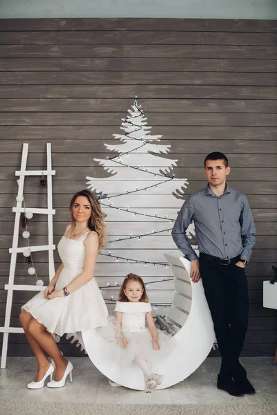 Bela jovem família posando por árvore de Natal pintada . — Fotografia de Stock