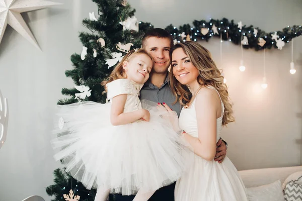 Amando a la familia acurrucándose en el columpio de Navidad. Árbol de Navidad . —  Fotos de Stock