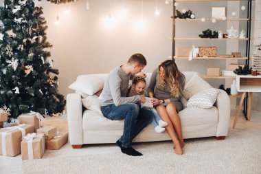 Noel hediyesi açan çocuklu bir aile. Noel ağacı..