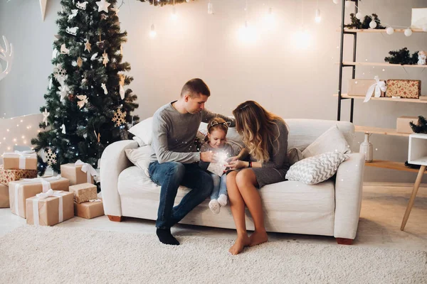 Rodina s dítětem otevření vánoční dárek.Vánoční stromeček. — Stock fotografie