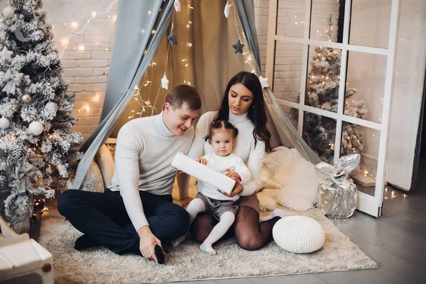 Hermosa familia joven bajo baldaquín. Decoraciones de Navidad . —  Fotos de Stock