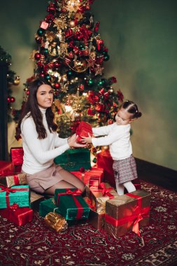 Anne ve kızı bir yığın hediyeyle sarılıyorlar..