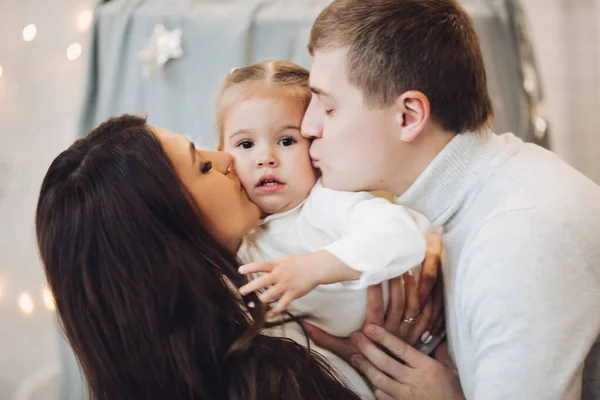 Hermosa familia caucásica en Christmas.Brunette madre y padre con adorable hija sonriendo a la cámara . —  Fotos de Stock