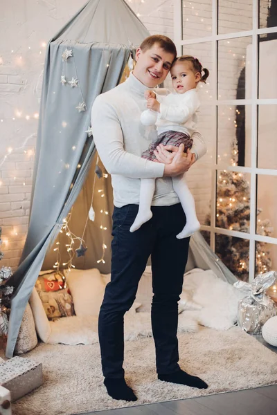 Papá con hija en el interior de Navidad. Padre sosteniendo a su adorable hija en brazos . —  Fotos de Stock