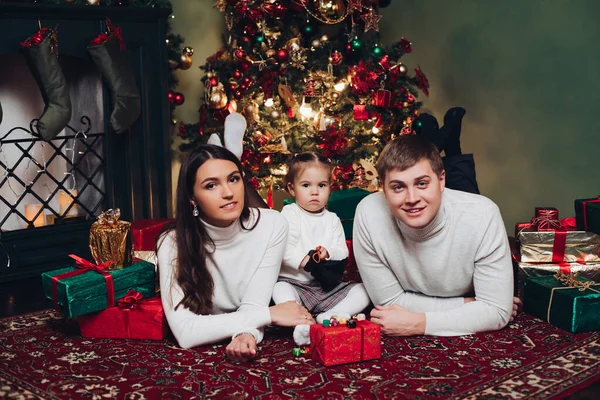 Rodina v dárky vedle vánočního stromečku. — Stock fotografie