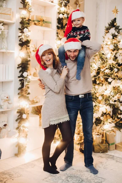 Una familia sonriente con su hijo en el sofá. Mujer y hombre sonriendo a la cámara . —  Fotos de Stock