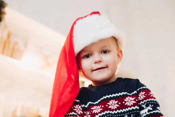 Lindo chico en Santa sombrero y suéter de invierno . —  Fotos de Stock