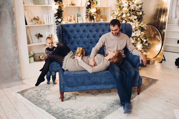 Hermosa familia joven con su pequeño hijo bajo las nevadas . —  Fotos de Stock