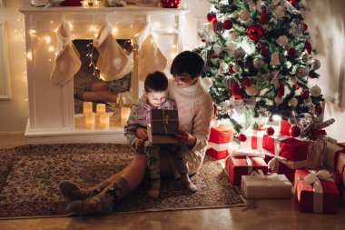 Anne ve oğul bir kutuda açık bir Noel hediyesi.