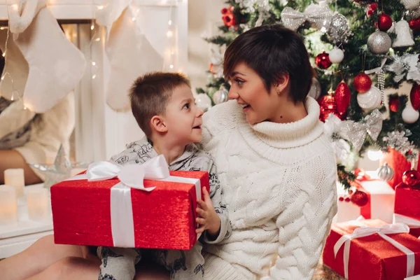 Šťastní rodiče ukazující vánoční ozdoby na stromě pro malého syna. — Stock fotografie