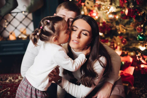 圣诞期间，小女孩满怀爱心地吻着妈妈. — 图库照片