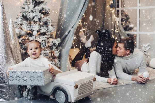 Familia bajo nevadas. habitación decorada para Navidad . —  Fotos de Stock