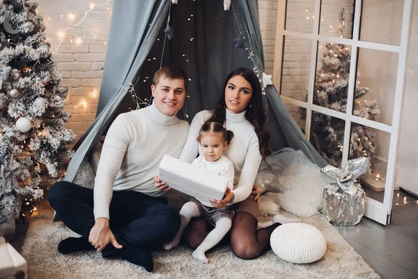 Krásná mladá rodina pod baldachýnem. Vánoční ozdoby. — Stock fotografie