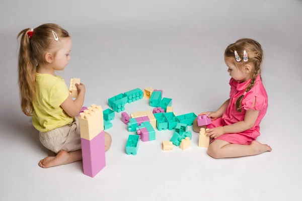दो लड़कियों तल पर बैठे और बिल्डिंग ब्लॉक के साथ खेलते — स्टॉक फ़ोटो, इमेज
