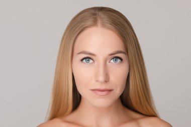 Beyaz stüdyo arka planında izole edilmiş güzel Avrupalı bir kadının orta boy portresi.