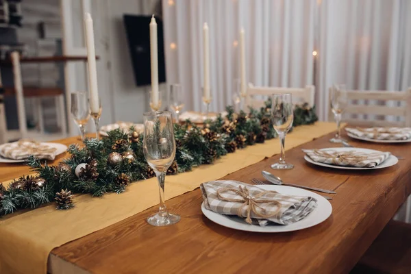 Krásný vánoční servírovací stůl se svíčkami a jedlovou výzdobou v útulném moderním interiéru — Stock fotografie