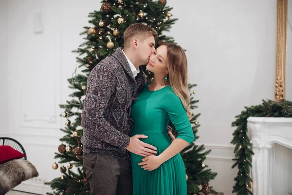 Ευτυχισμένο ζευγάρι φιλιά αίσθημα αγάπης στο χριστουγεννιάτικο δέντρο πολυτελή εσωτερική διακόσμηση — Φωτογραφία Αρχείου