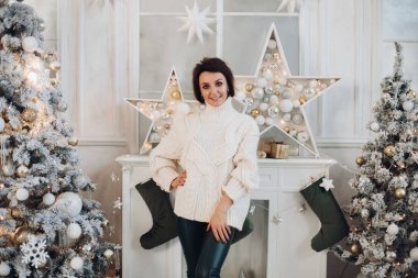 Evdeki şöminenin yanında duran mutlu genç bayan.