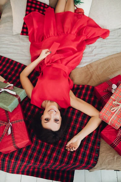 Sonriente dama atractiva acostada en cuadros cerca de regalos —  Fotos de Stock