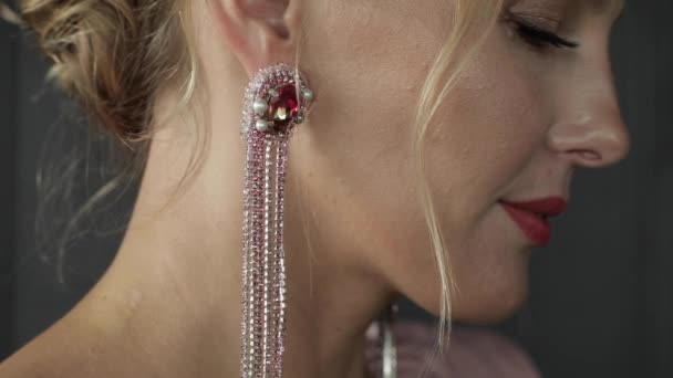 Κοντινό πλάνο της όμορφης γυναίκας με το ροζ σκουλαρίκι. — Αρχείο Βίντεο