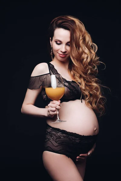 Frumoasa femeie însărcinată se uită la un pahar cu suc în mâini — Fotografie, imagine de stoc