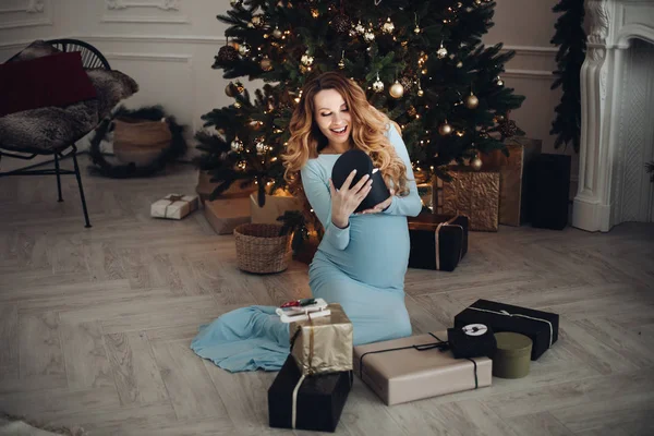Glad vacker gravid kvinna håller låda med en gåva — Stockfoto