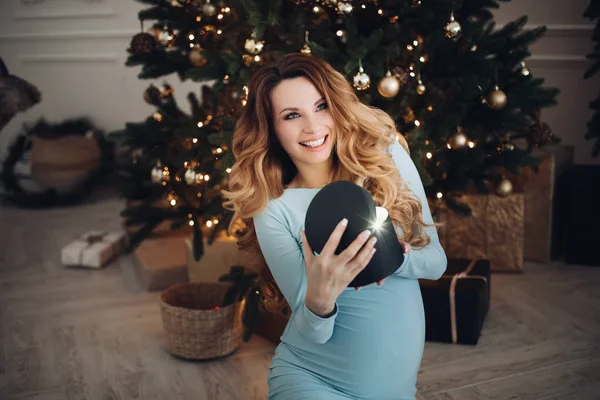 O femeie gravidă fericită care deschide cadoul de vacanță cu emoții pozitive — Fotografie, imagine de stoc