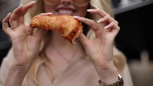 Közelkép mosolygós nő letépi friss étvágygerjesztő croissant kézzel pozitív érzelmek — Stock videók