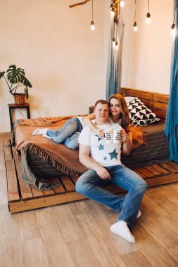 Genç çift stüdyoda göbek üstü yatıyorlar..