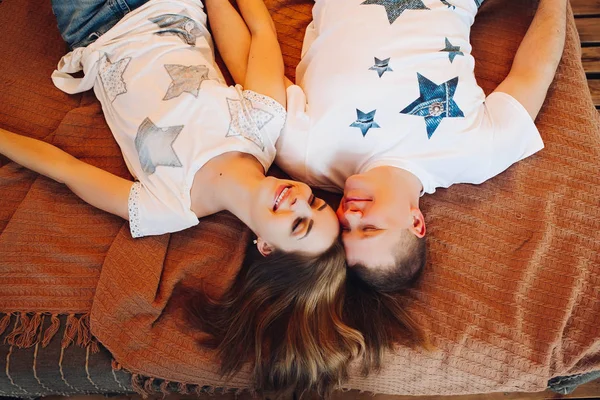 Vista superior de pareja joven acostados juntos en la cama en el estudio . — Foto de Stock