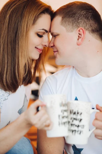 Romantic couple sitting on windows hill with creative cups and enjoying in love. — Stock Photo, Image