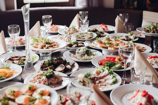 Bankettafel geserveerd met diverse koude snacks en salades. — Stockfoto