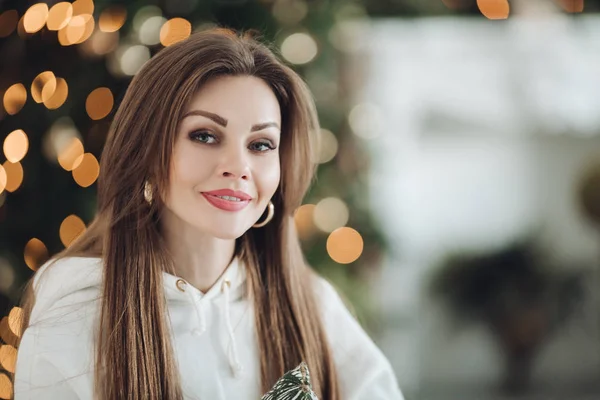 Happy beautiful woman in white suit posing near Christmas tree — 스톡 사진