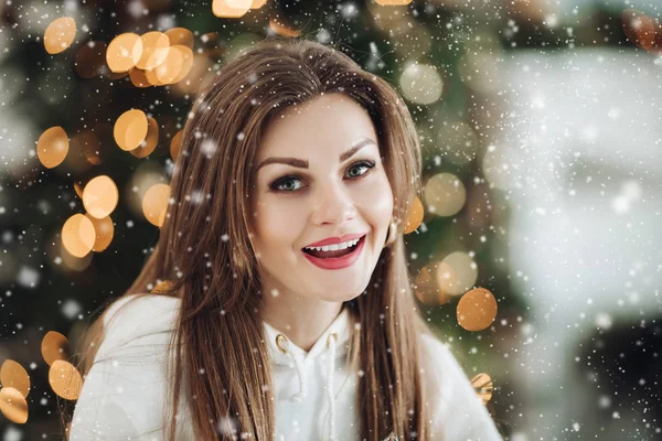 Glad vacker kvinna i vit kostym poserar nära julgran — Stockfoto