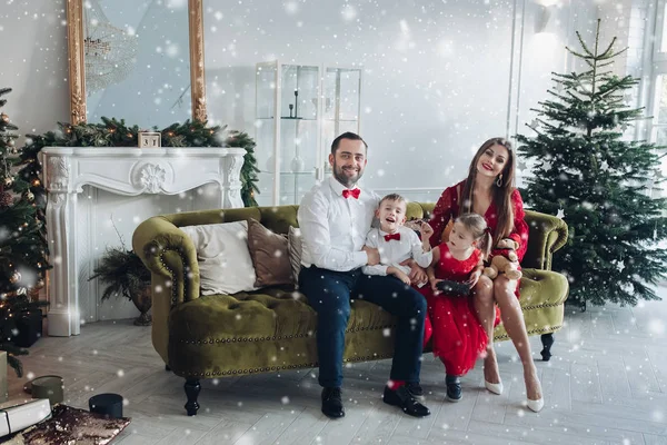 Feliz familia festiva sonriendo posando en el interior de vacaciones de diciembre de lujo en el fondo del árbol de Navidad —  Fotos de Stock