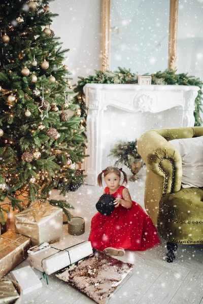 Мила дівчинка в червоній сукні з різдвяним подарунком.. — стокове фото